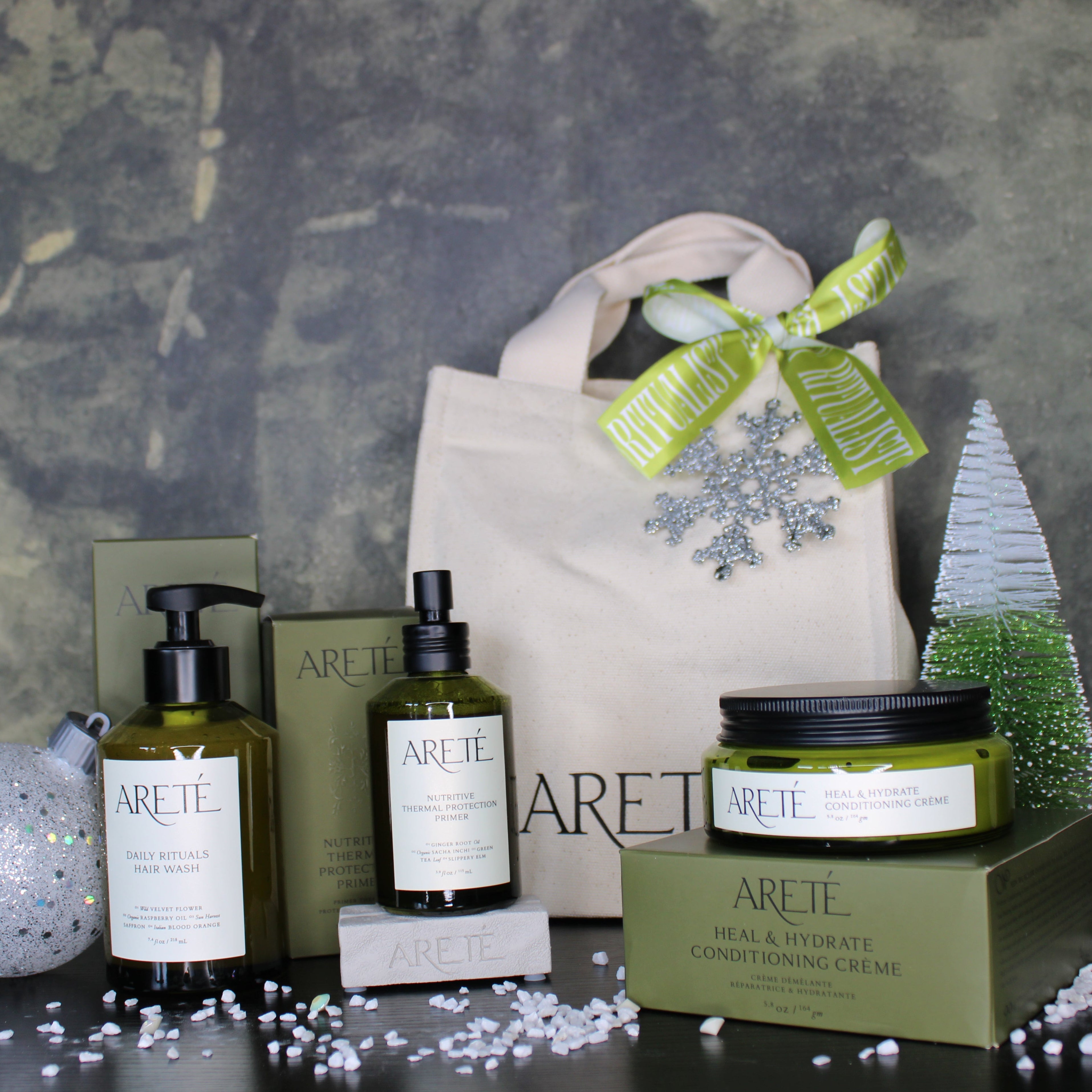 Arette skincare products with a decorative bag and Christmas tree on a textured surface.