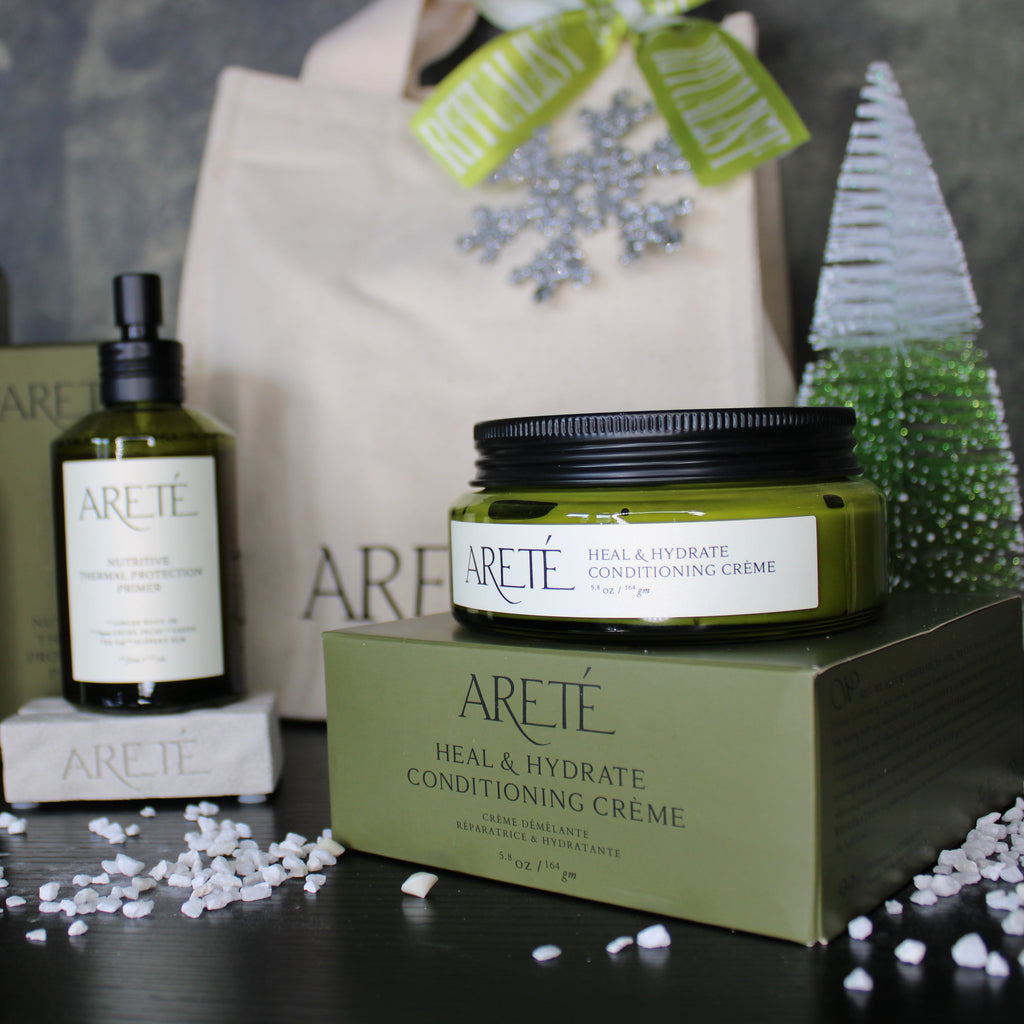 Areété skincare products including bottles and a jar on a dark surface with a decorative background.