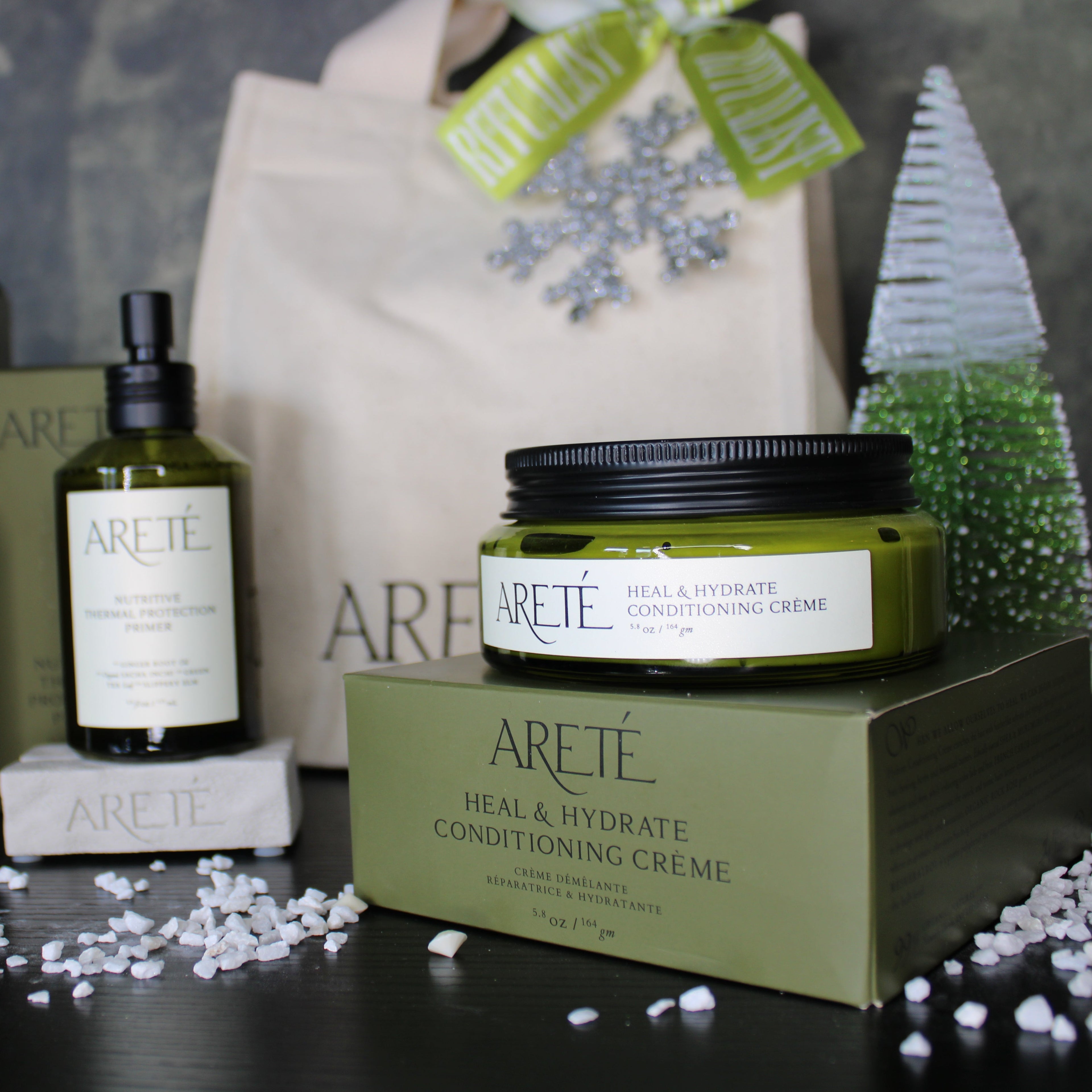 Areété skincare products including bottles and a jar on a dark surface with a decorative background.