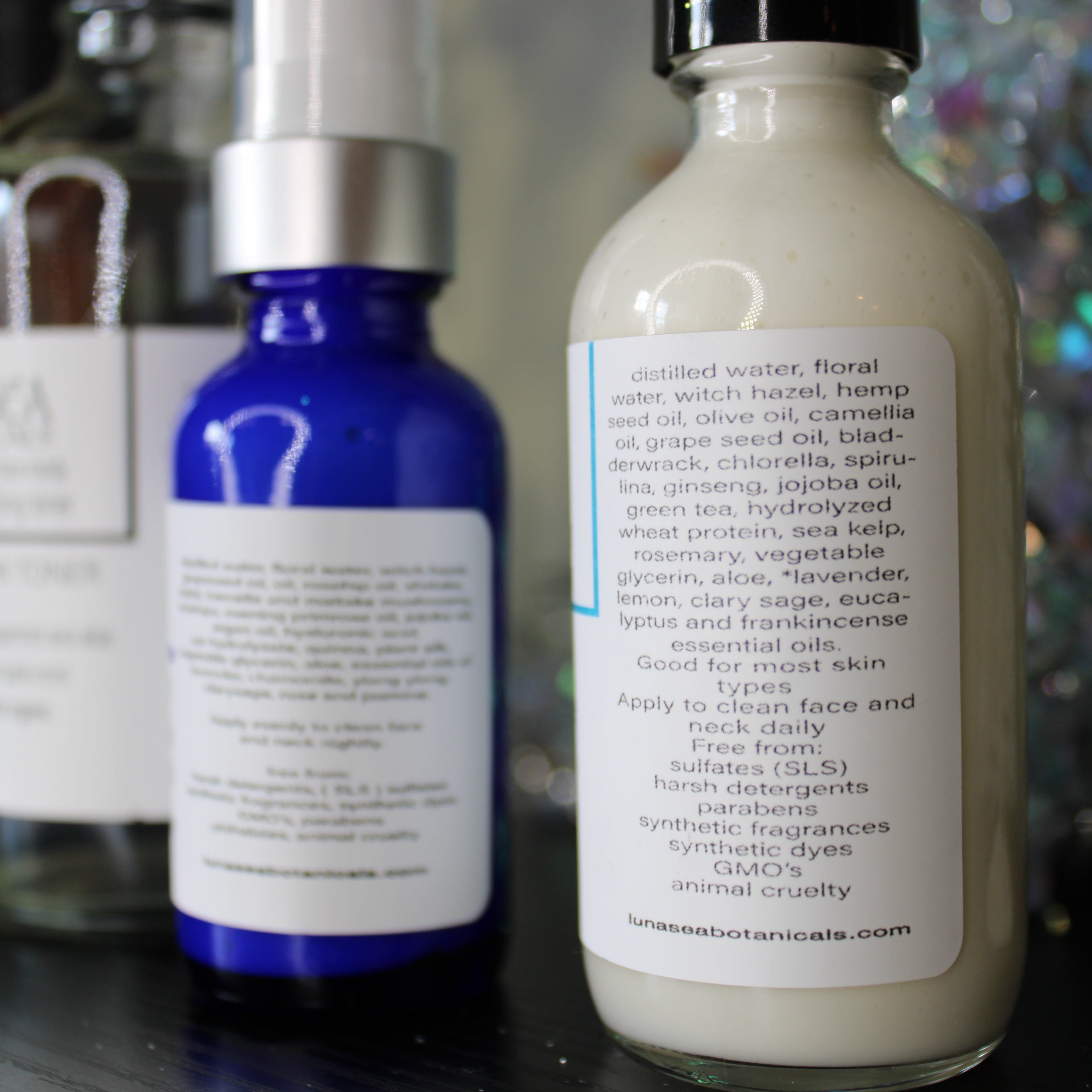 Three skincare bottles with visible labels on a dark surface.
