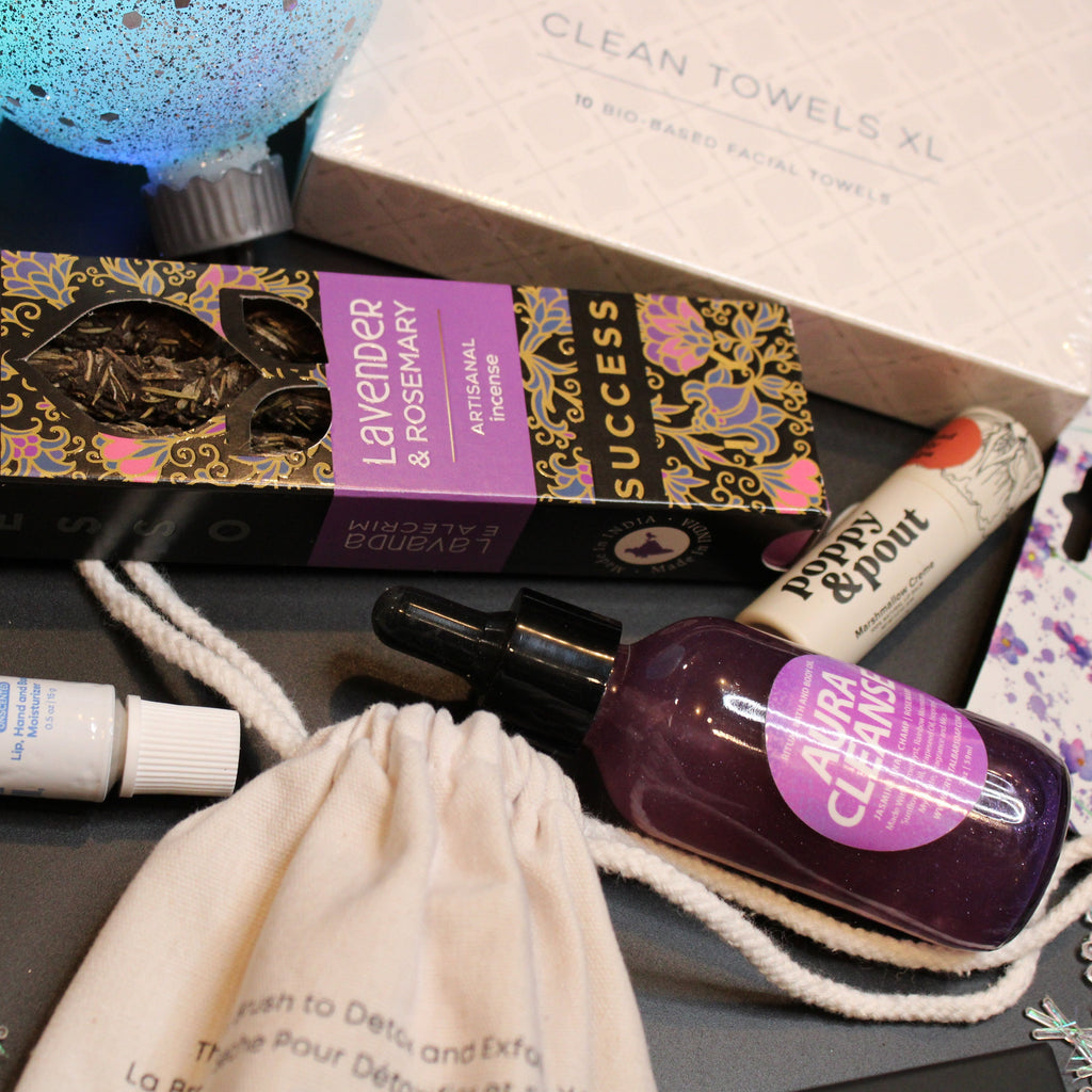 Collection of beauty products including a box, lip balm, and other items on a dark surface.