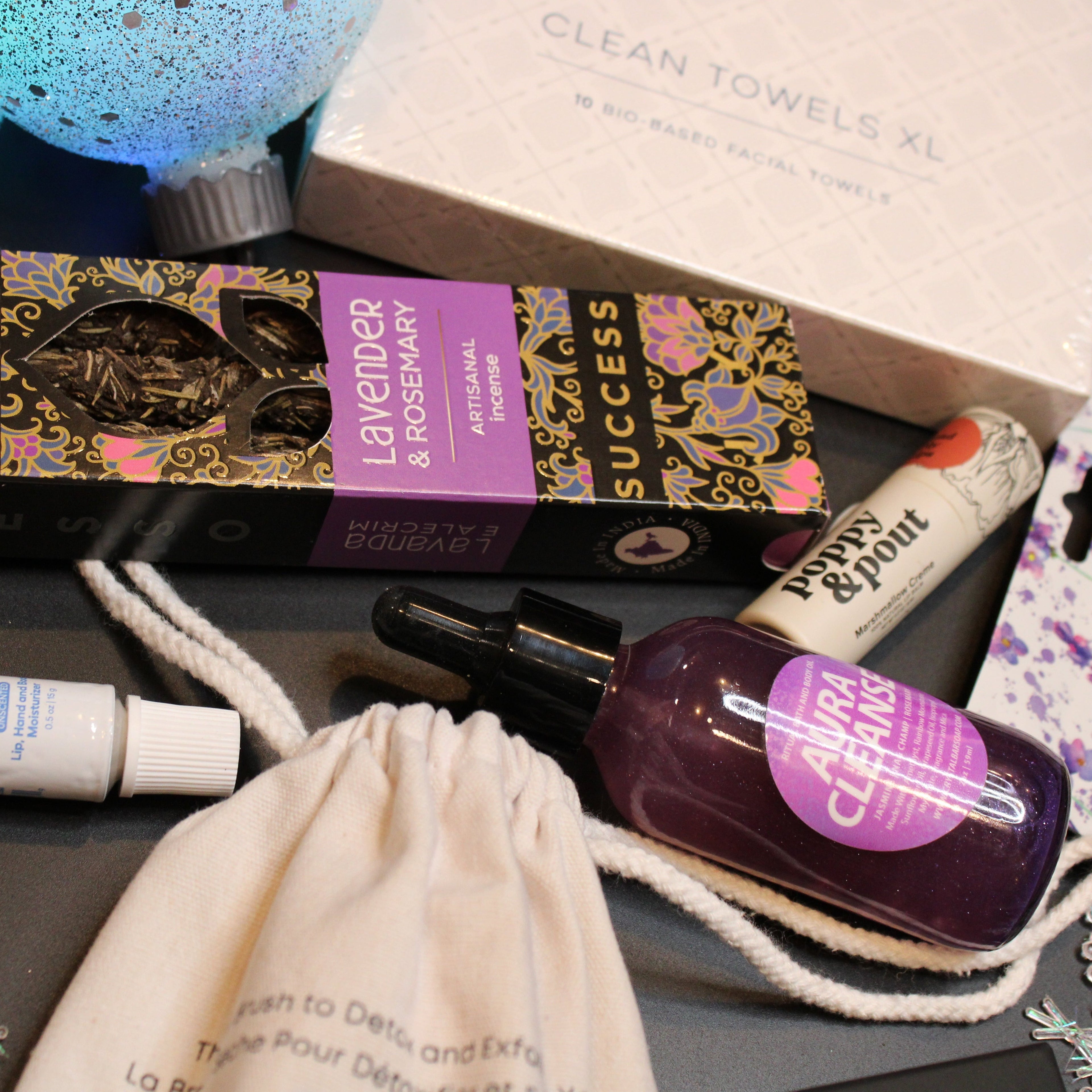 Collection of beauty products including a box, lip balm, and other items on a dark surface.