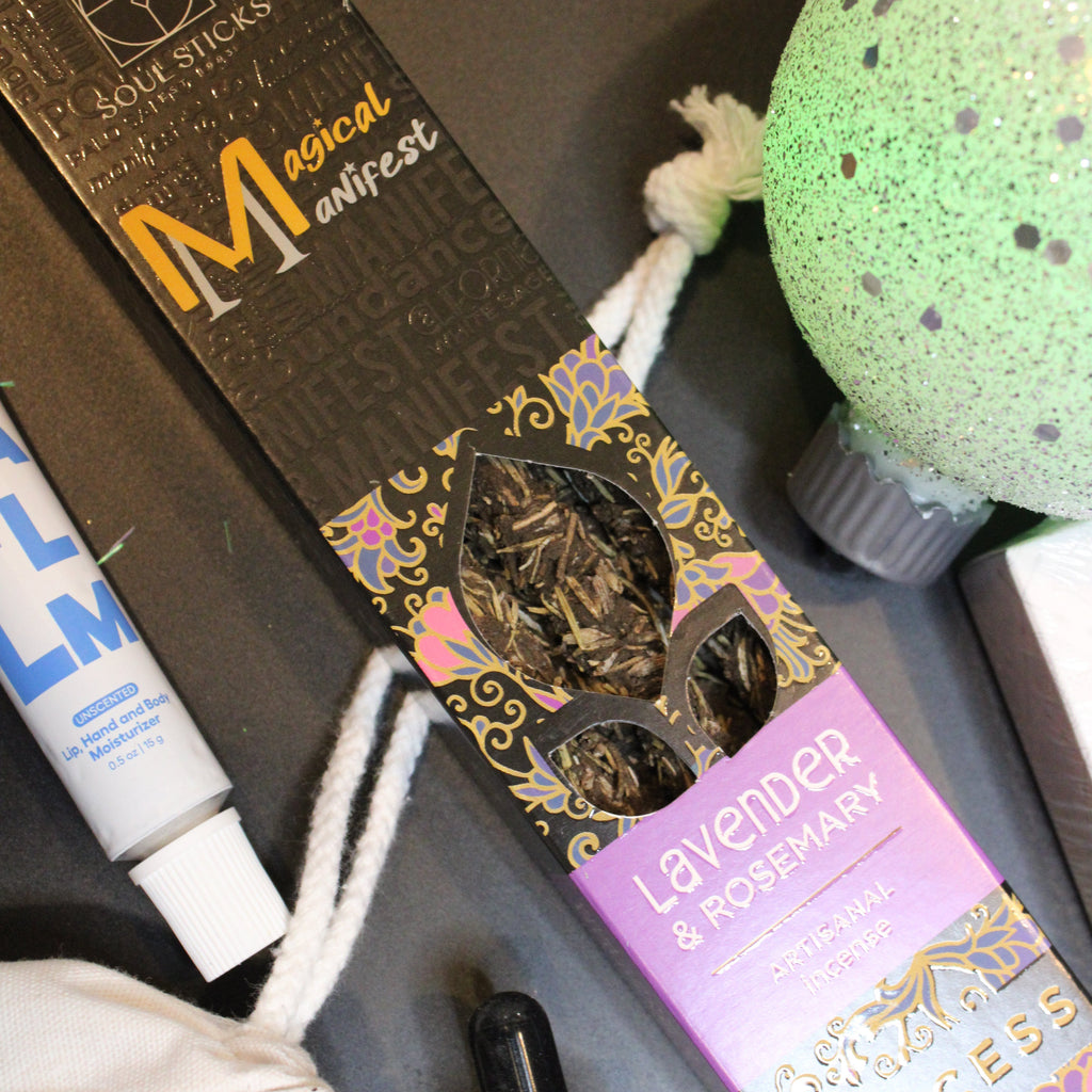 Various beauty products including a box of makeup, a tube, and a bottle on a dark surface.