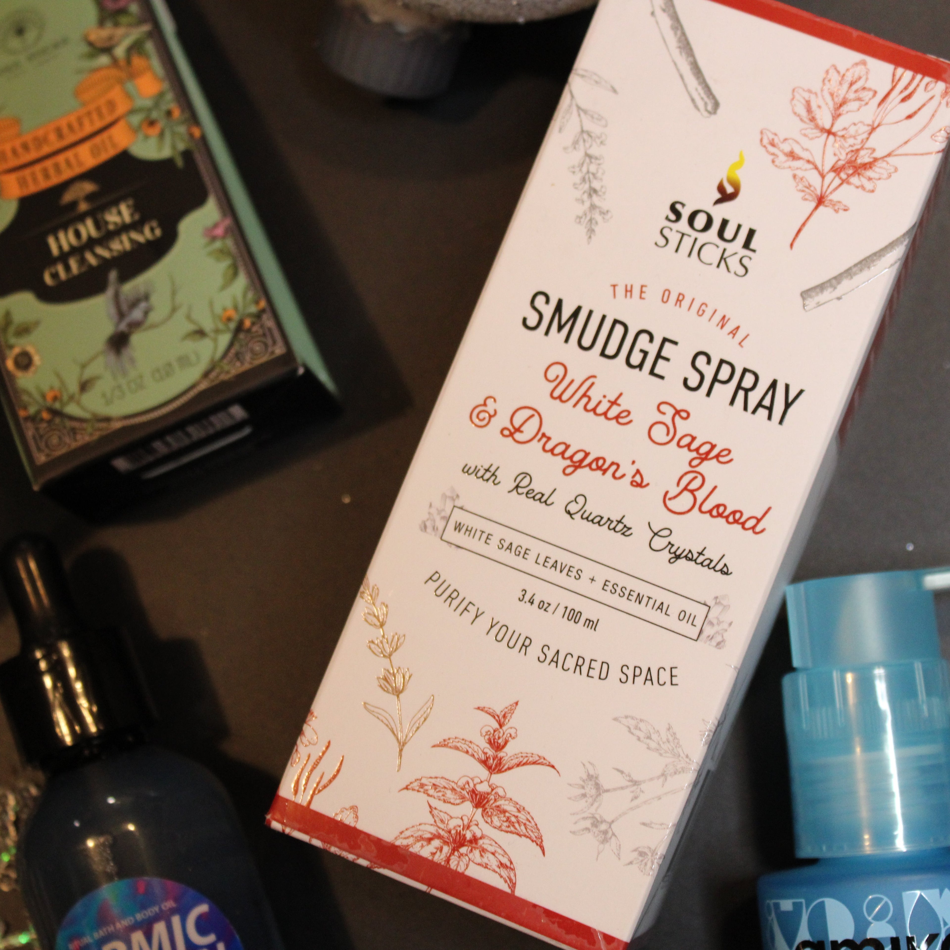 Soul Sticks Smudge Spray packaging with a blue spray bottle on a dark surface
