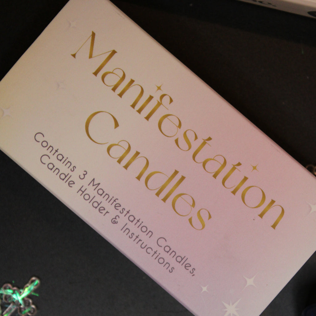 Manifestation candles packaging with text on a dark surface