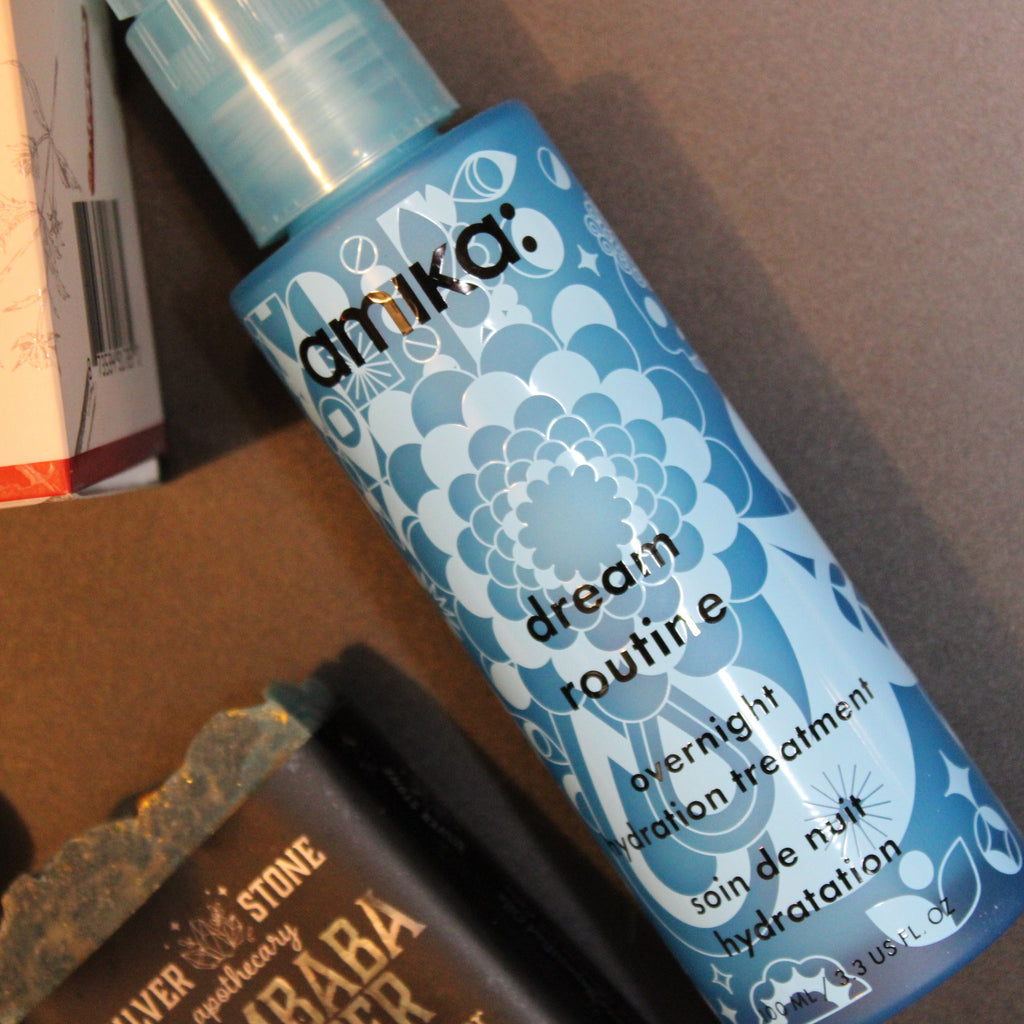 Amika skincare product on a surface with other items