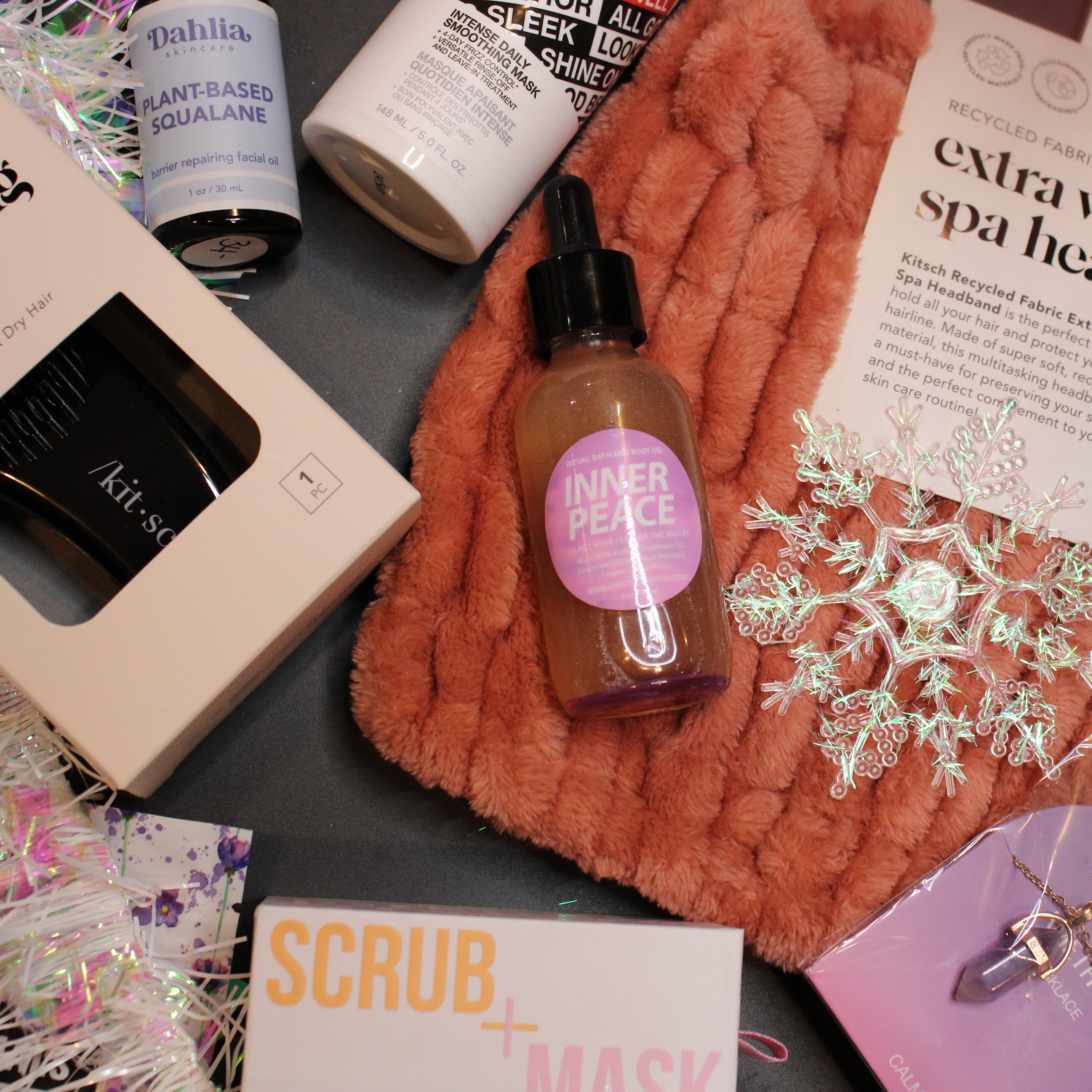 Assorted beauty products including a bottle, boxes, and a headband on a textured surface.