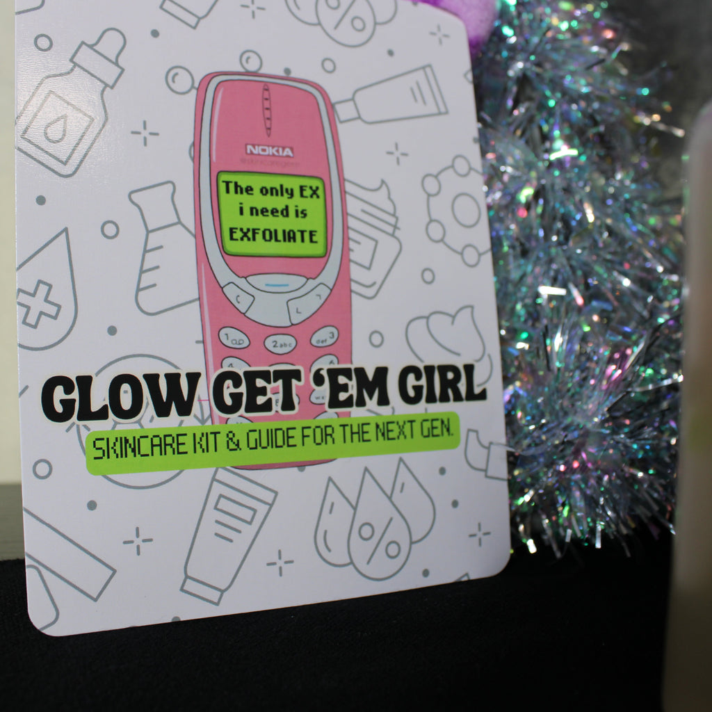 Skincare kit packaging with a pink phone illustration and text, against a blurred background.